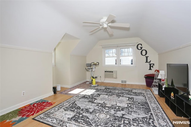 interior space with visible vents, a ceiling fan, wood finished floors, lofted ceiling, and a wall mounted AC
