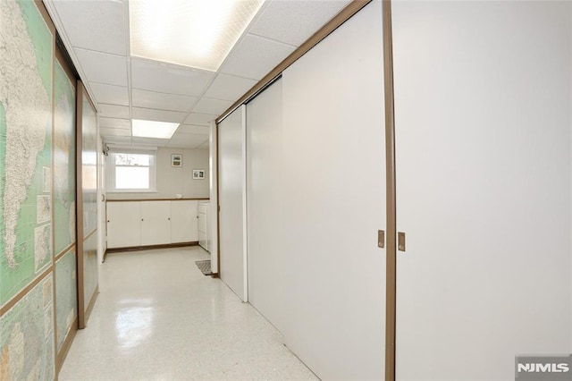 hall with a paneled ceiling