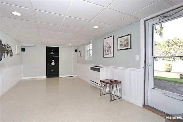 interior space with recessed lighting, heating unit, wainscoting, and a drop ceiling