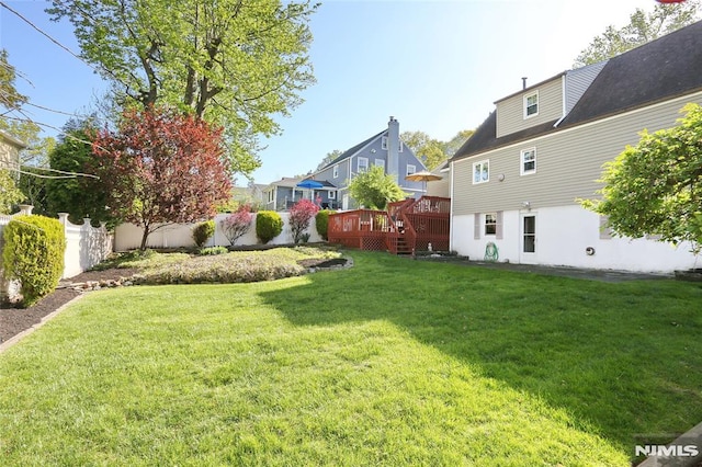 view of yard with fence and a wooden deck