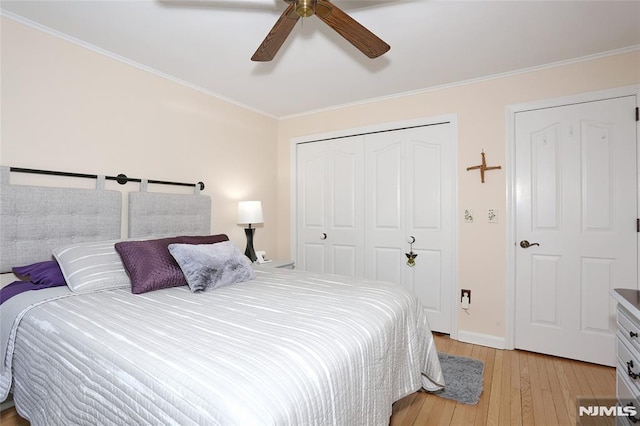 bedroom with light wood-style floors, a ceiling fan, baseboards, ornamental molding, and a closet