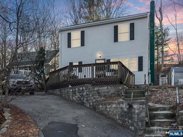 view of front of property with a chimney, stairway, and a deck