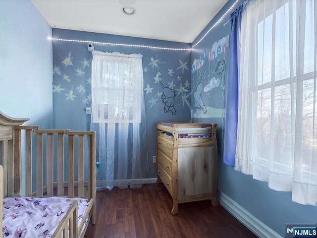 bedroom with wallpapered walls, wood finished floors, and baseboards