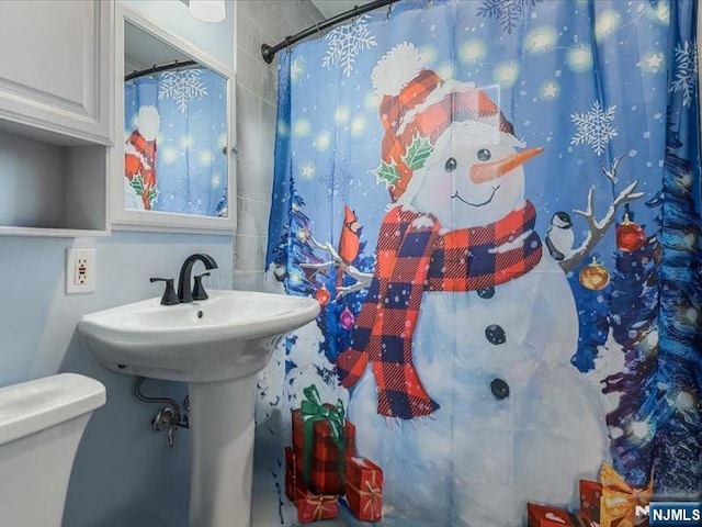 full bathroom with toilet and a shower with curtain