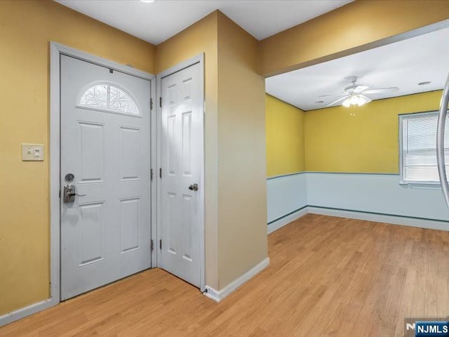entrance foyer with light wood-type flooring, a ceiling fan, and baseboards