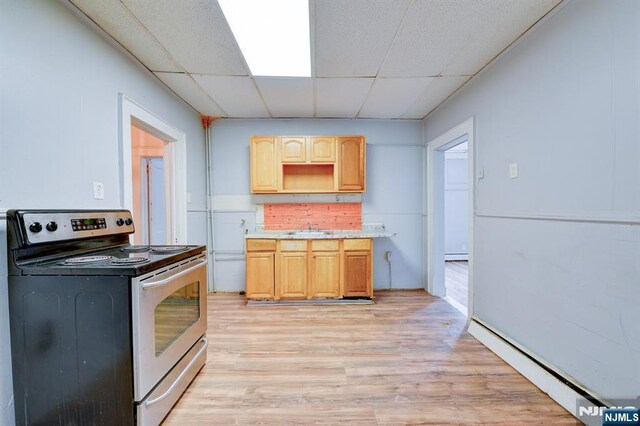 kitchen with baseboard heating, light brown cabinets, a sink, stainless steel range with electric cooktop, and a paneled ceiling