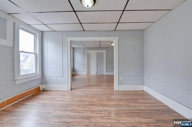 spare room with light wood-style floors and a drop ceiling