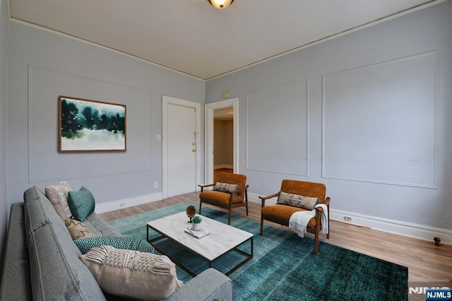 living area with baseboards and wood finished floors