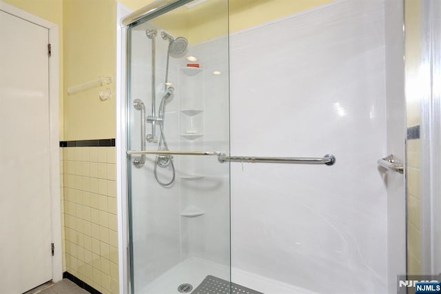 311 Grand Ave Unit 23, Englewood, NJ 07631 - full bathroom with tile walls, a stall shower, and tile patterned flooring