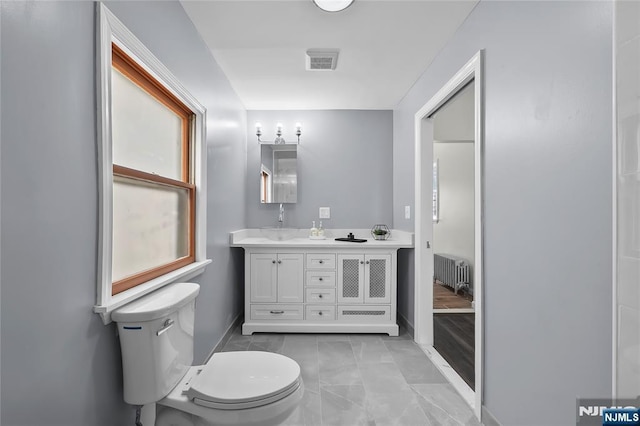85 Anderson Ave, Wallington, NJ 07057 - bathroom featuring radiator heating unit, toilet, baseboards, and double vanity