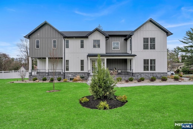 view of front of property with a porch, a front yard, and board and batten siding