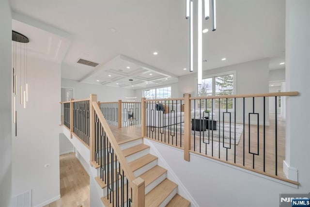 stairway with recessed lighting, coffered ceiling, wood finished floors, visible vents, and beamed ceiling