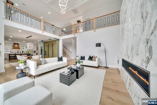 living room with stairs, wood finished floors, a high ceiling, and a fireplace