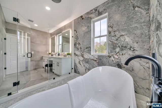 bathroom with a stall shower, vanity, tile walls, marble finish floor, and visible vents