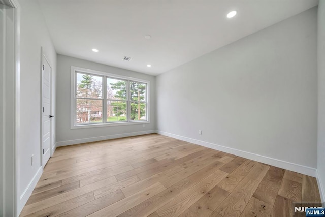 empty room featuring light wood-style flooring, baseboards, and recessed lighting