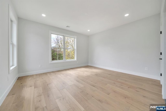 unfurnished room with light wood-style flooring, baseboards, and plenty of natural light