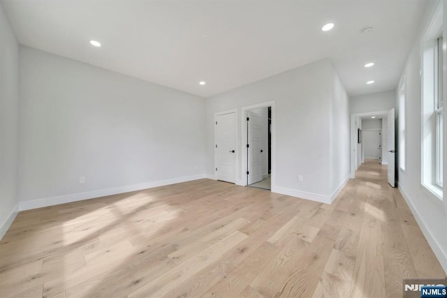 unfurnished bedroom with baseboards, light wood finished floors, and recessed lighting
