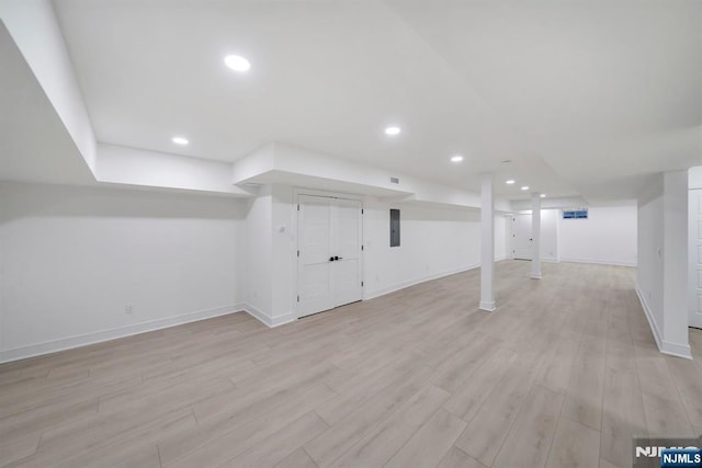finished basement featuring baseboards, visible vents, light wood finished floors, and recessed lighting
