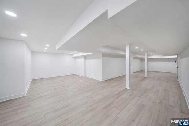 finished basement featuring recessed lighting, light wood-type flooring, and baseboards