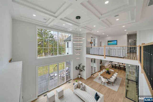 living room with beamed ceiling, wood finished floors, and coffered ceiling