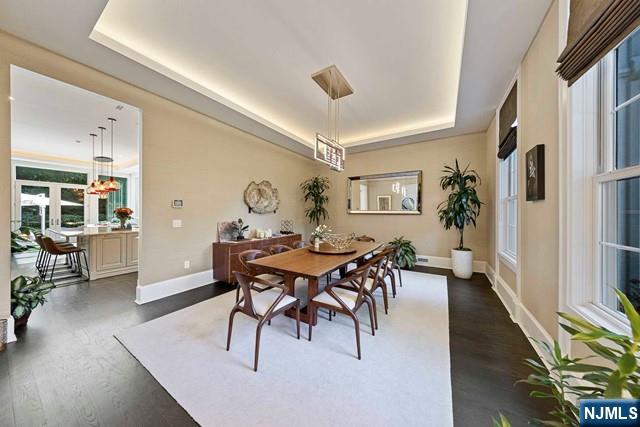 354 Hardenburgh Ave, Demarest, NJ 07627 - dining space with a raised ceiling, dark wood-style floors, and baseboards