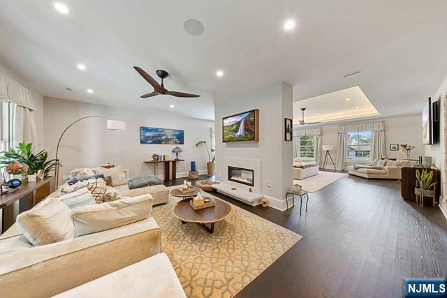 354 Hardenburgh Ave, Demarest, NJ 07627 - living room featuring recessed lighting, dark wood-type flooring, ceiling fan, a glass covered fireplace, and baseboards