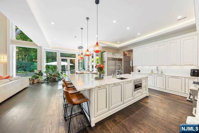 354 Hardenburgh Ave, Demarest, NJ 07627 - kitchen featuring built in appliances, a sink, dark wood-style flooring, and white cabinets