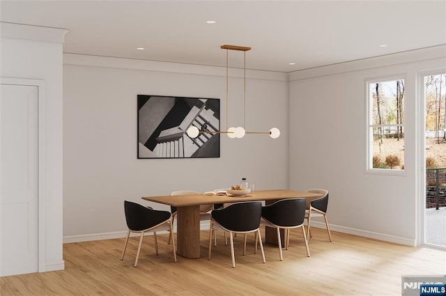 dining space featuring light wood-style floors and baseboards