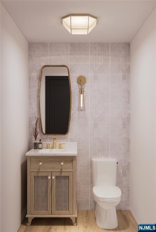bathroom featuring toilet, wood finished floors, and vanity