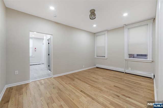 empty room with recessed lighting, light wood finished floors, and baseboard heating