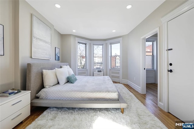 bedroom featuring baseboards, wood finished floors, and recessed lighting