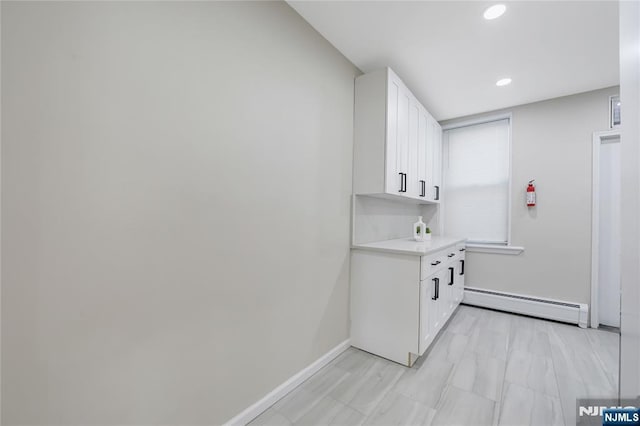 laundry area with a baseboard heating unit, baseboards, and recessed lighting