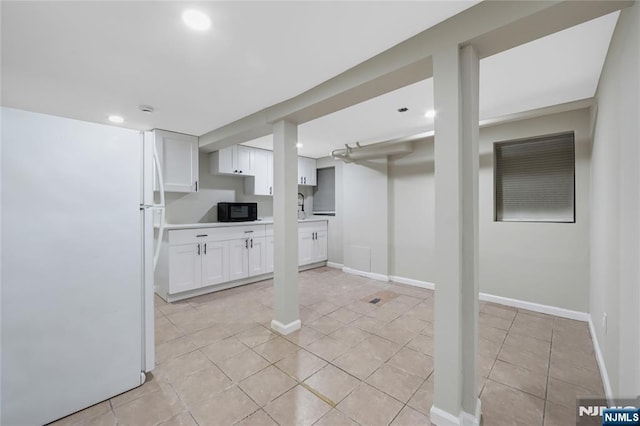 finished basement featuring baseboards, freestanding refrigerator, recessed lighting, and light tile patterned flooring