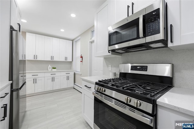 kitchen featuring baseboard heating, white cabinets, stainless steel appliances, and recessed lighting