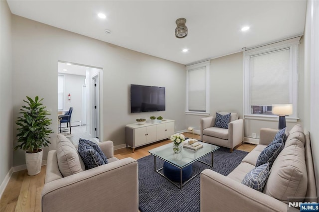 living room with baseboards, recessed lighting, and light wood-style floors