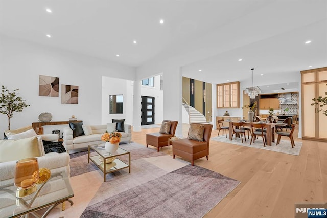 living area featuring light wood finished floors, recessed lighting, and stairway