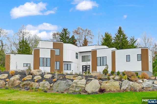 rear view of house featuring a lawn