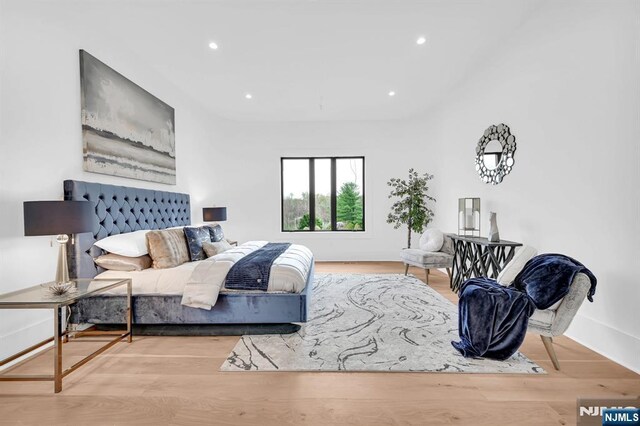 bedroom featuring baseboards, wood finished floors, and recessed lighting