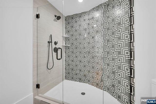 bathroom with toilet and a stall shower