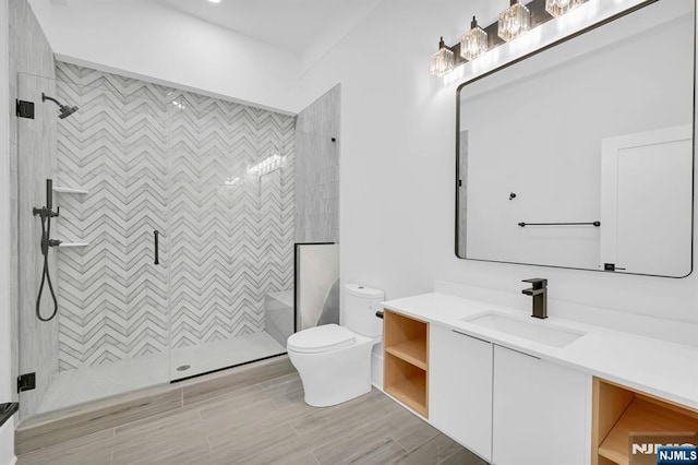 full bathroom featuring wood finished floors, vanity, a shower stall, and toilet