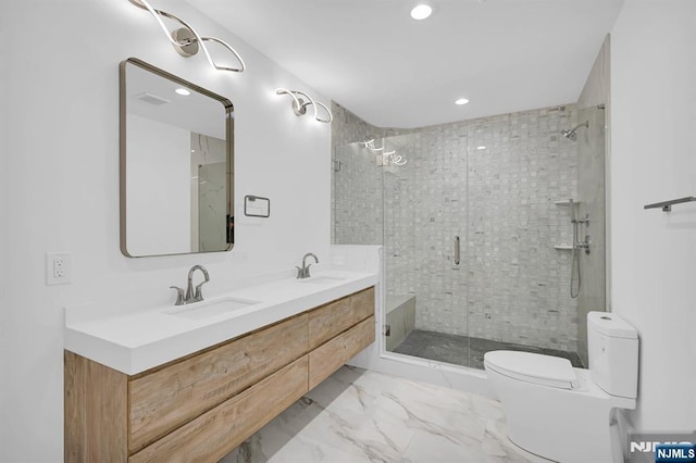 bathroom with recessed lighting, toilet, a stall shower, and a sink