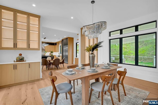 dining space featuring recessed lighting, light wood-style floors, and an inviting chandelier