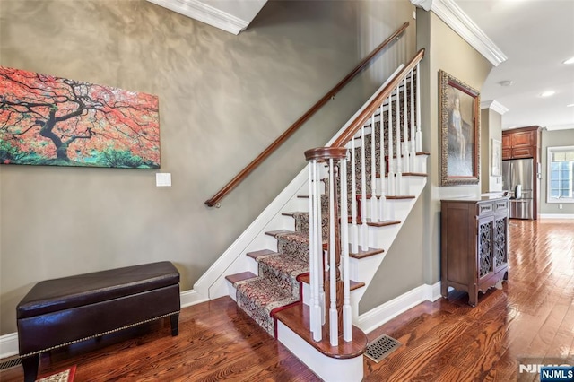 stairway with recessed lighting, wood finished floors, visible vents, ornamental molding, and baseboards
