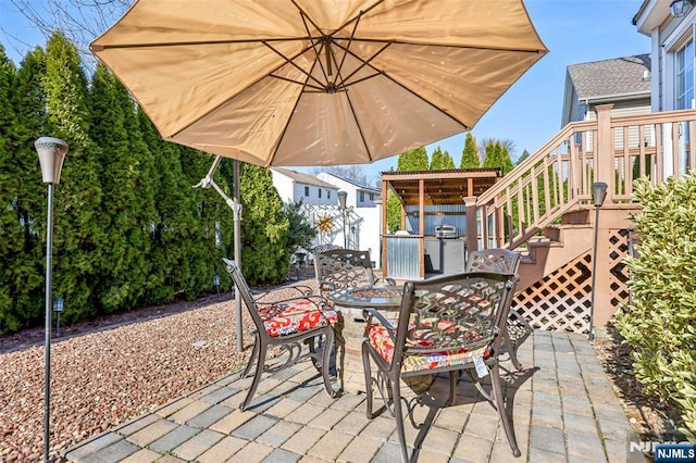 view of patio / terrace with a jacuzzi, stairs, fence, outdoor dining area, and a deck