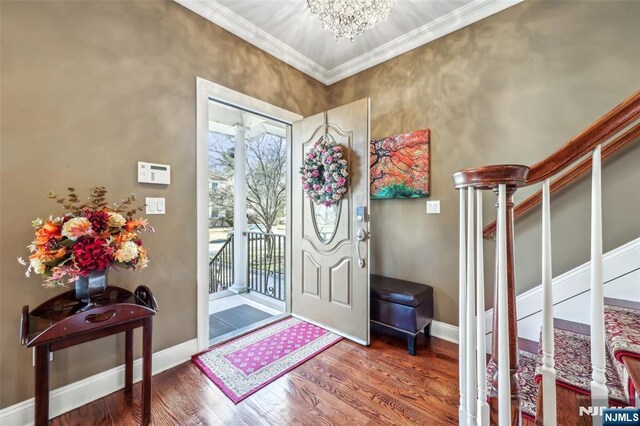 foyer featuring plenty of natural light, wood finished floors, and stairway