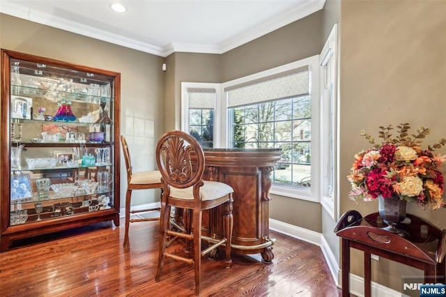 sitting room featuring a dry bar, baseboards, recessed lighting, wood finished floors, and ornamental molding