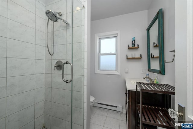 bathroom with baseboard heating, a tile shower, tile patterned flooring, and vanity