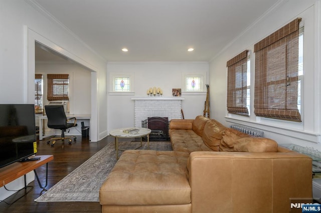 living room featuring recessed lighting, a brick fireplace, dark wood-type flooring, radiator heating unit, and ornamental molding