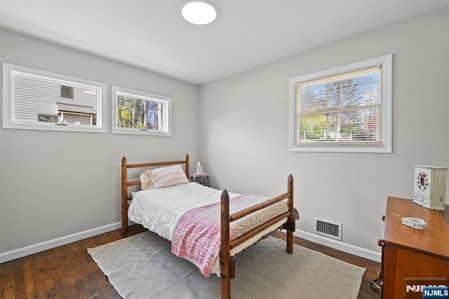 bedroom featuring visible vents, wood finished floors, and baseboards