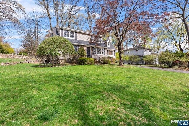 traditional-style home featuring a front lawn